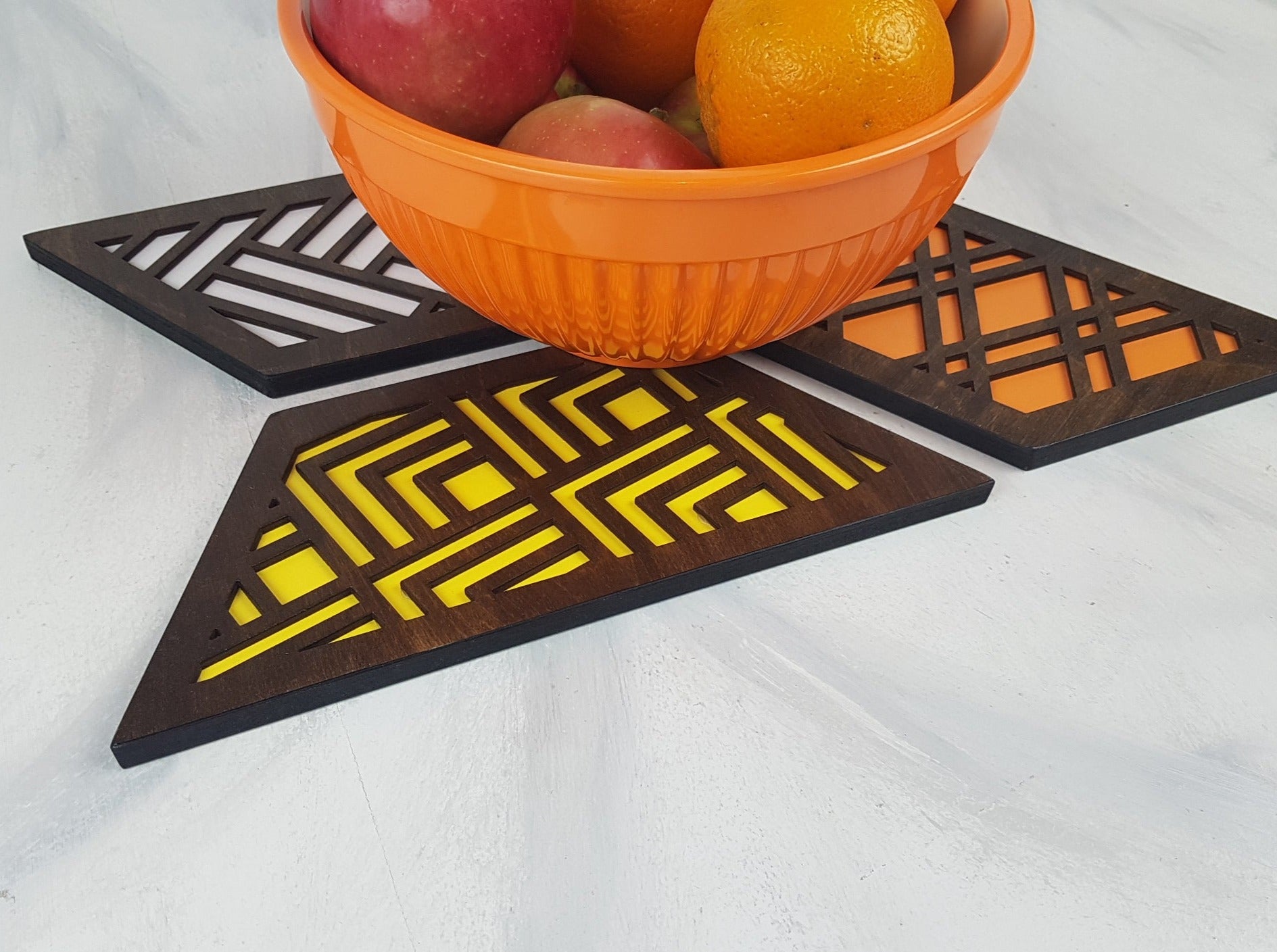 A set of hexagonal wooden geometric trivets with a mid-century modern pattern.