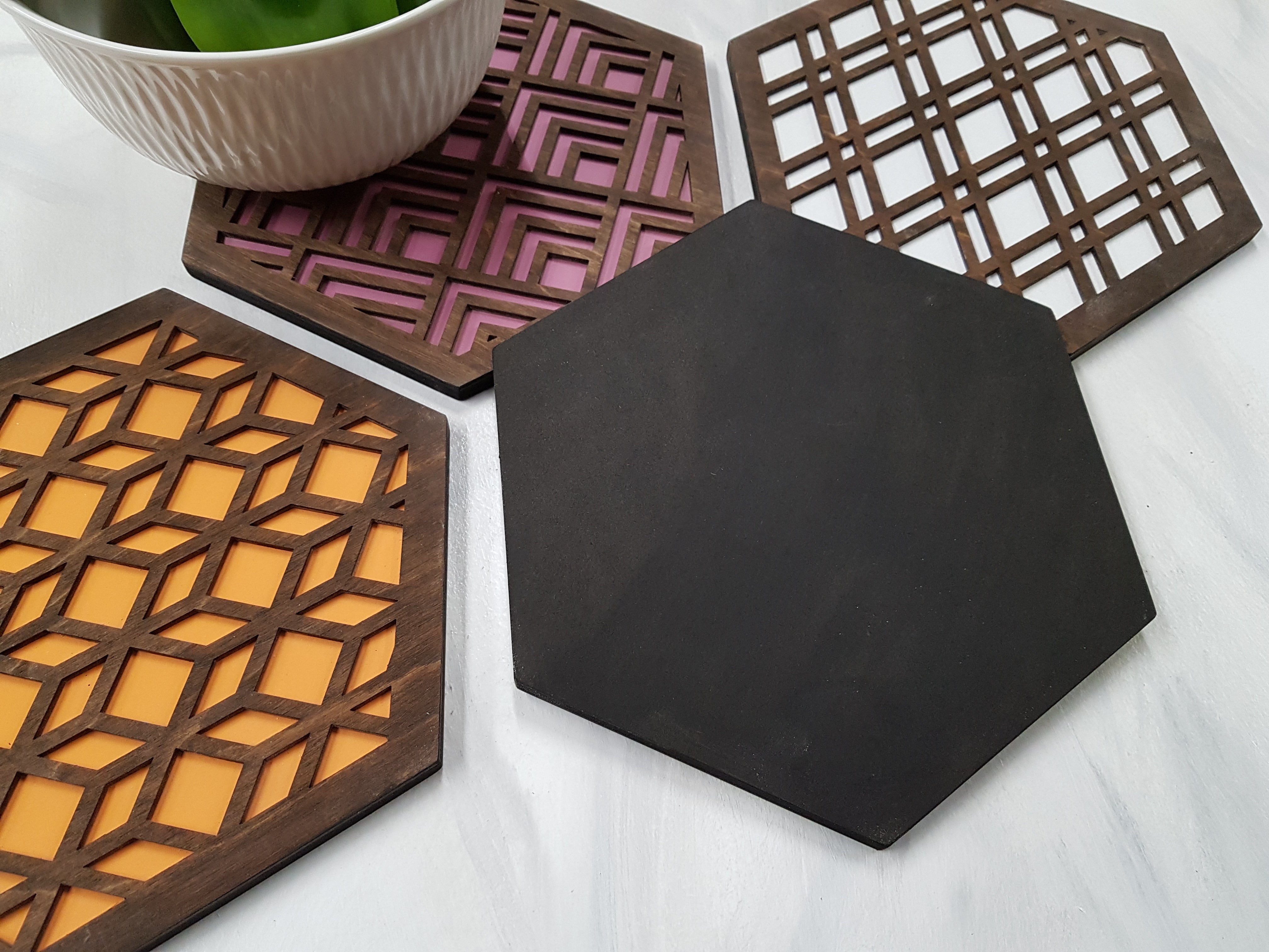 Close-up of walnut wood hexagon trivet flipped over to show smooth, finished back surface. Demonstrates high-quality laser-cut plywood construction with non-toxic water-based sealant on both sides. Durable Canadian handmade kitchen decor.