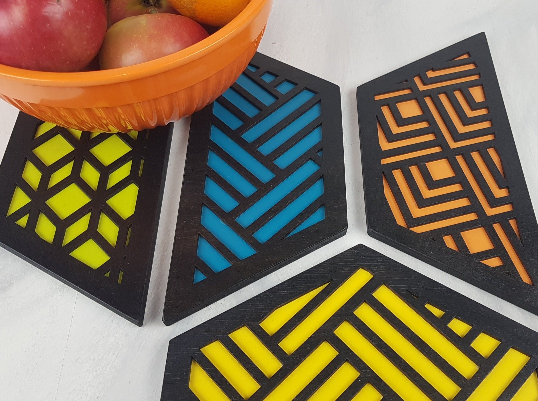 A set of hexagonal wooden geometric trivets with a mid-century modern pattern.