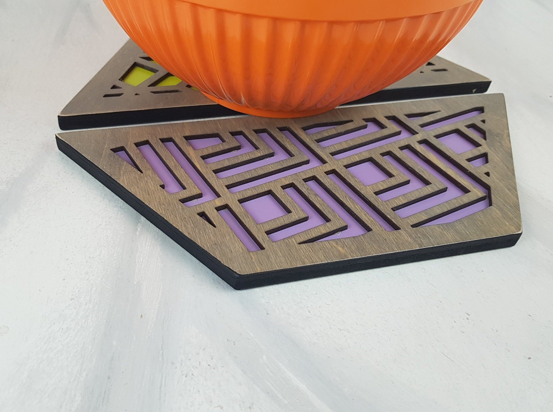 A close-up of one of the hexagonal trivets with a black stain finish. Handmade Heat Resistant Kitchen Accessories