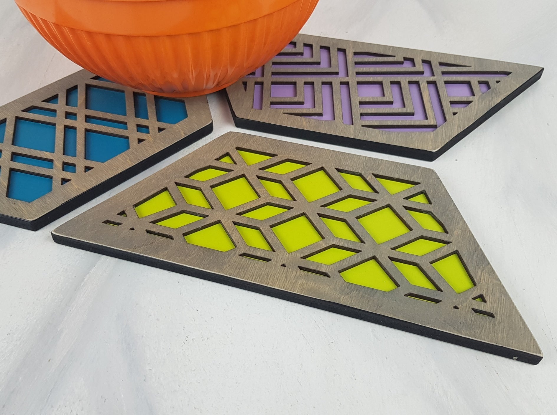 A set of hexagonal wooden geometric trivets with a mid-century modern pattern.